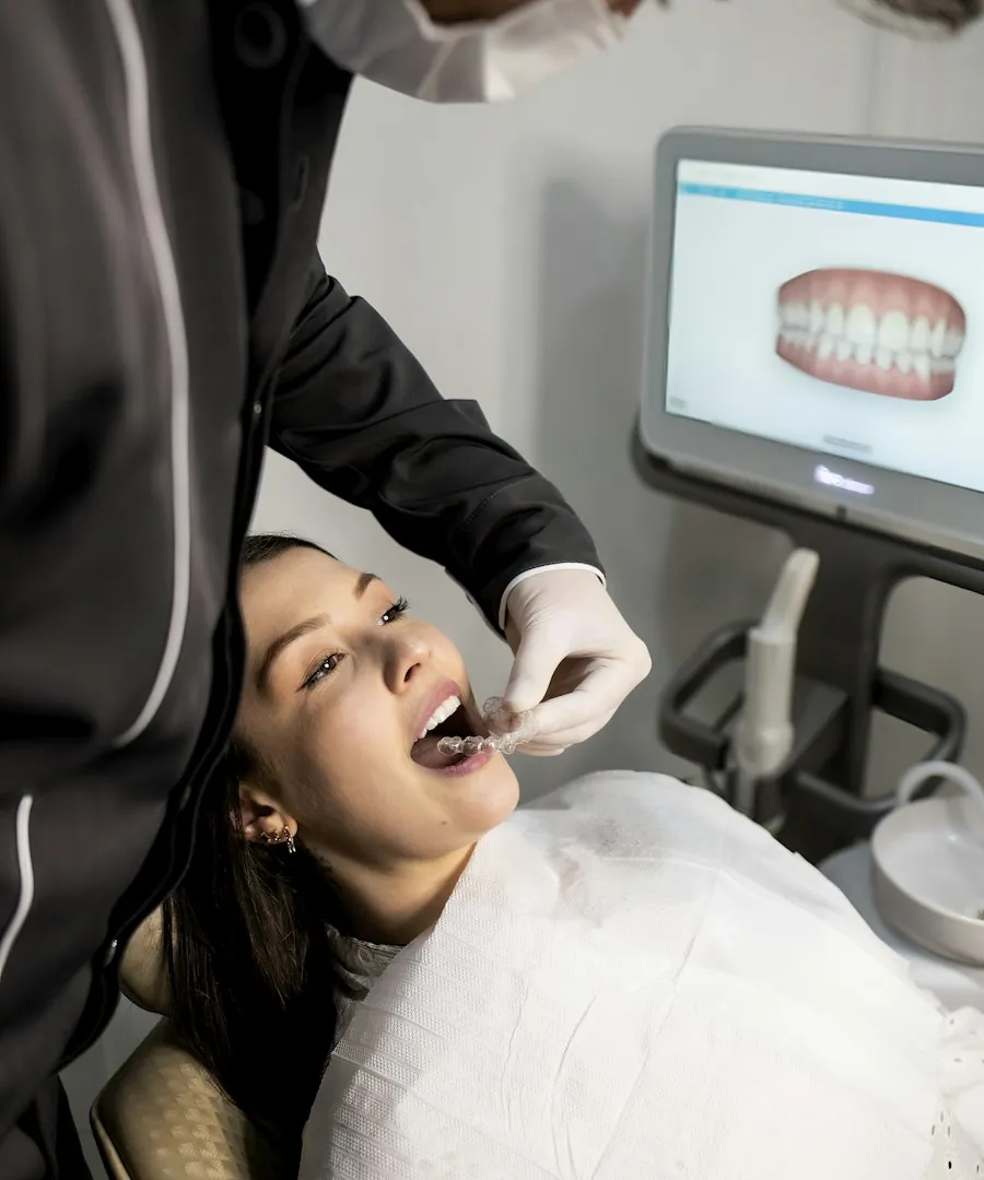 Dentista realizando escaneamento digital com o sorriso do paciente na tela